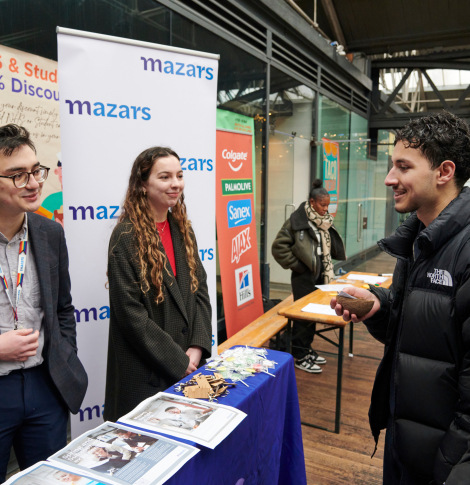 Young people interacting with business representatives.